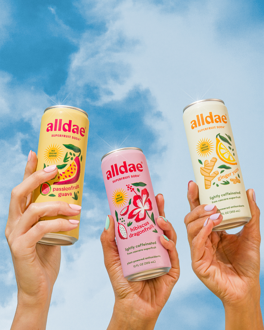 alldae superfruit soda's variety pack held in the air by hands against a blue sky background, as a nod to the gentle afternoon boost these provide.